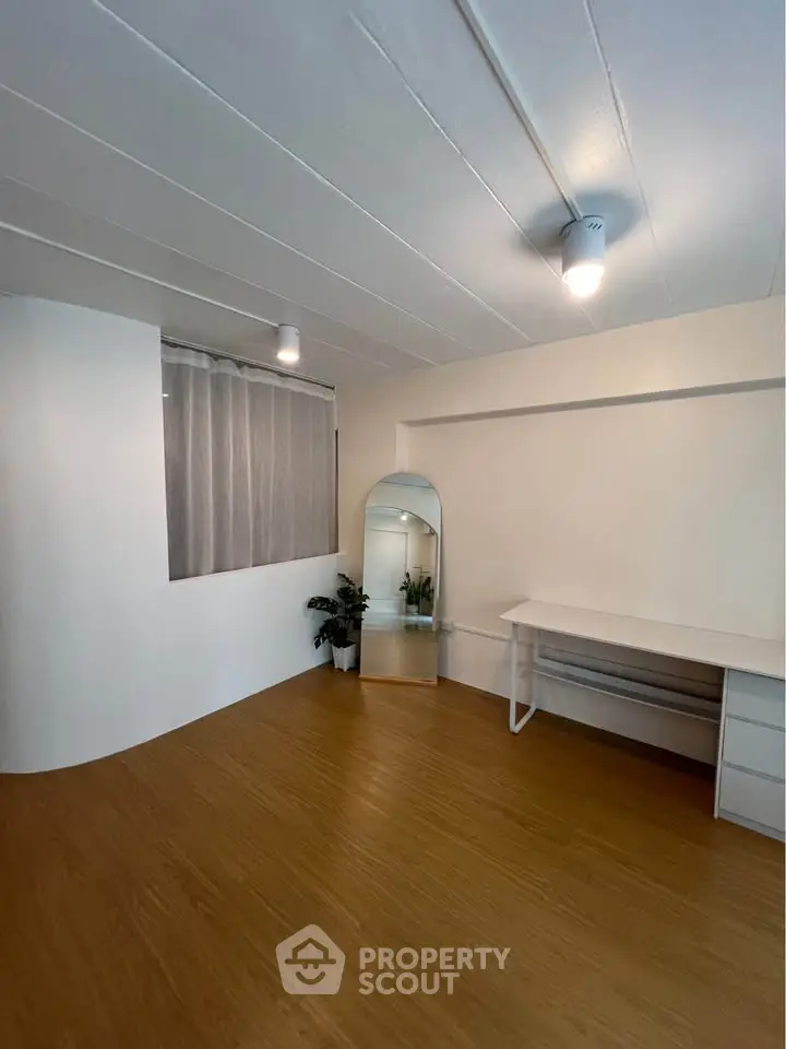Spacious minimalist room with wooden flooring and modern decor