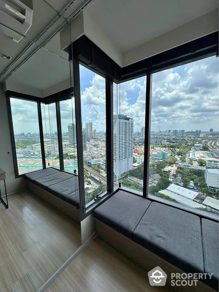 Stunning high-rise apartment with panoramic city views and cozy window seating.