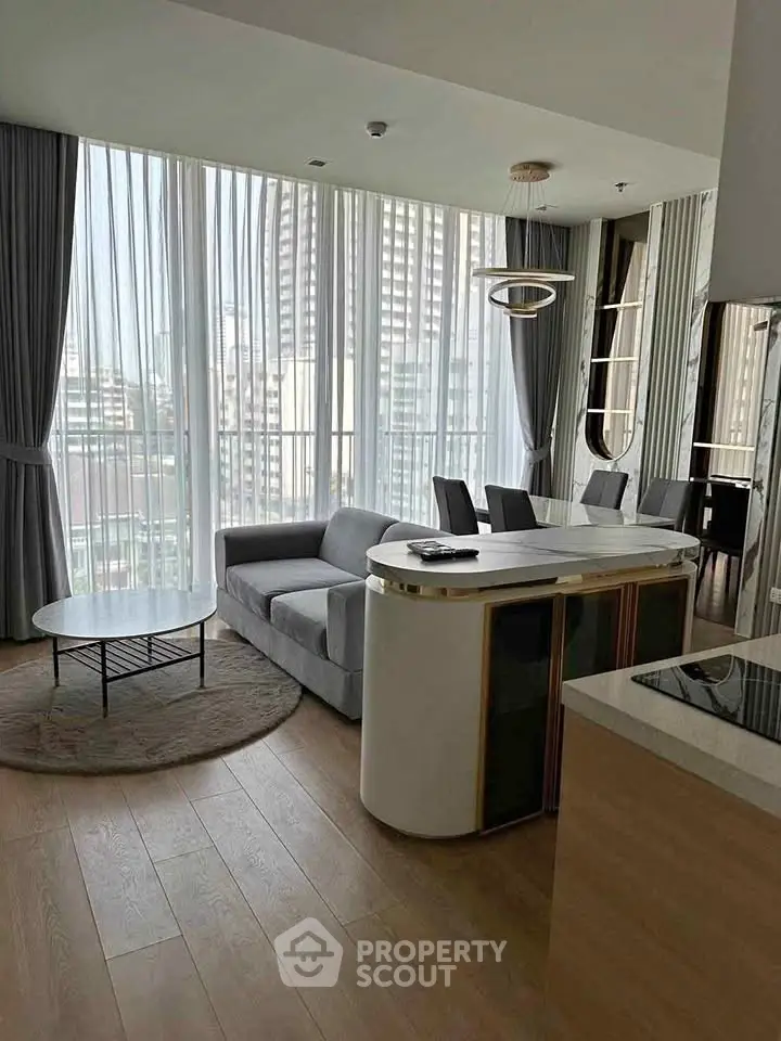 Modern living room with floor-to-ceiling windows and stylish furniture in a high-rise apartment.