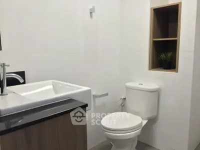 Modern bathroom with sleek fixtures and built-in shelving, perfect for contemporary living.