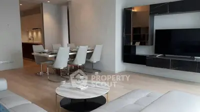 Modern living room with sleek furniture and open dining area, perfect for contemporary living.