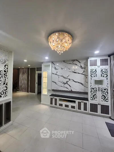 Luxurious living room with elegant chandelier and marble accent wall