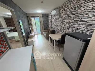 Modern apartment interior with stylish stone accent wall and open layout, featuring a cozy living area and balcony view.