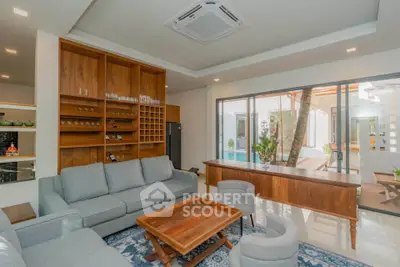 Spacious living room with modern furniture and pool view, perfect for relaxation and entertainment.