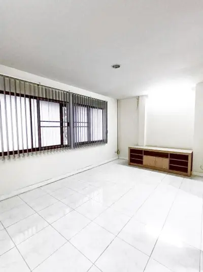 Spacious empty room with tiled floor and large windows, perfect for customization.