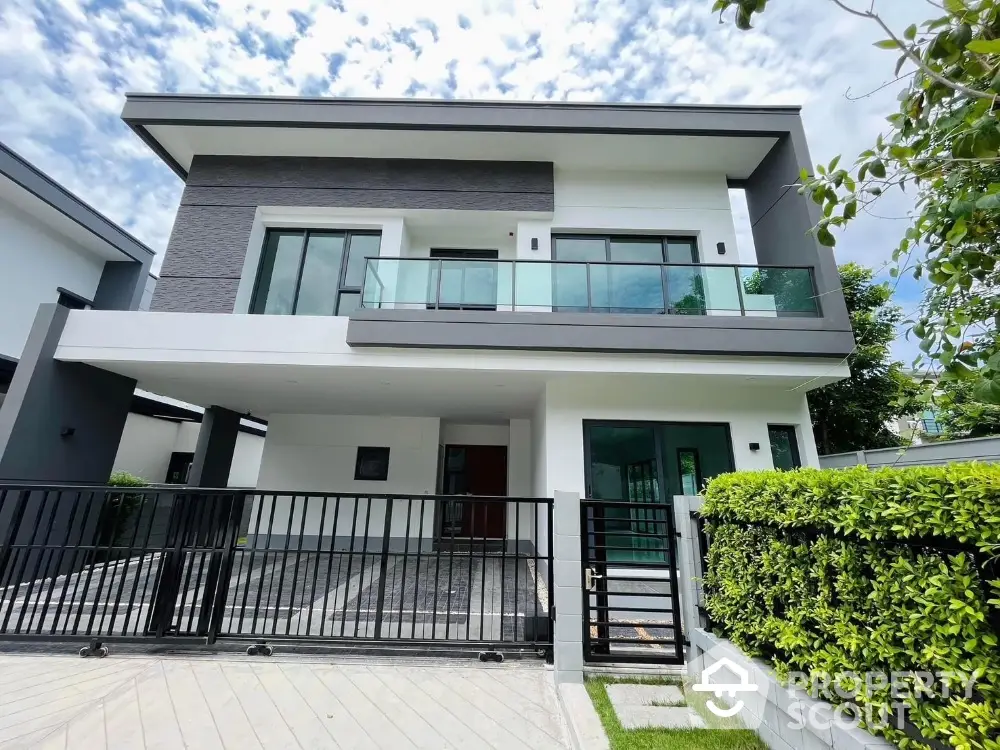 Modern two-story house with sleek design and spacious balcony in a serene neighborhood.