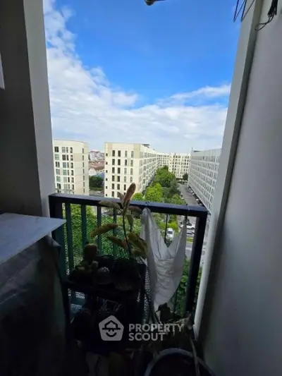 Stunning balcony view of modern apartment complex with lush greenery and clear blue sky.
