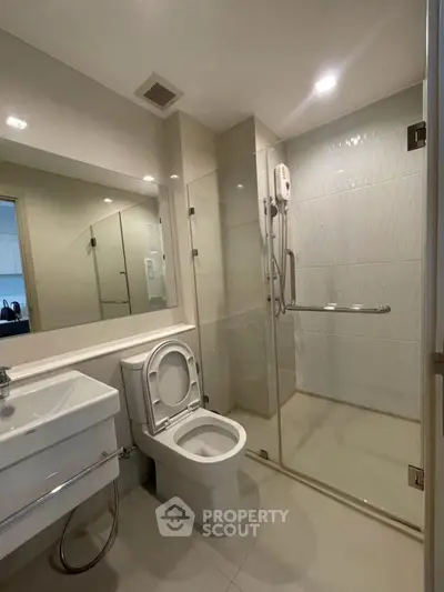 Modern bathroom with glass shower and sleek fixtures in a contemporary home.