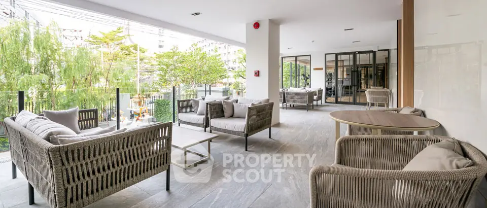 Spacious outdoor seating area with modern wicker furniture and lush greenery view.