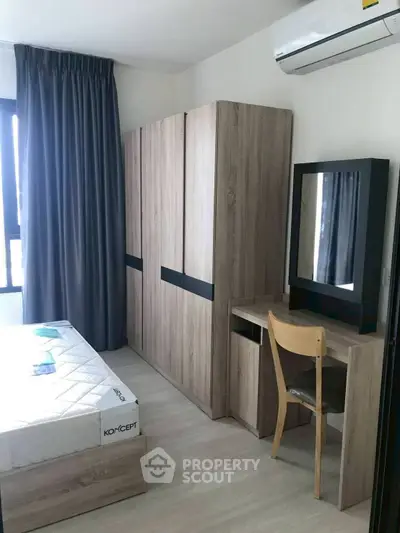 Modern bedroom with sleek wooden furniture and large window for natural light.