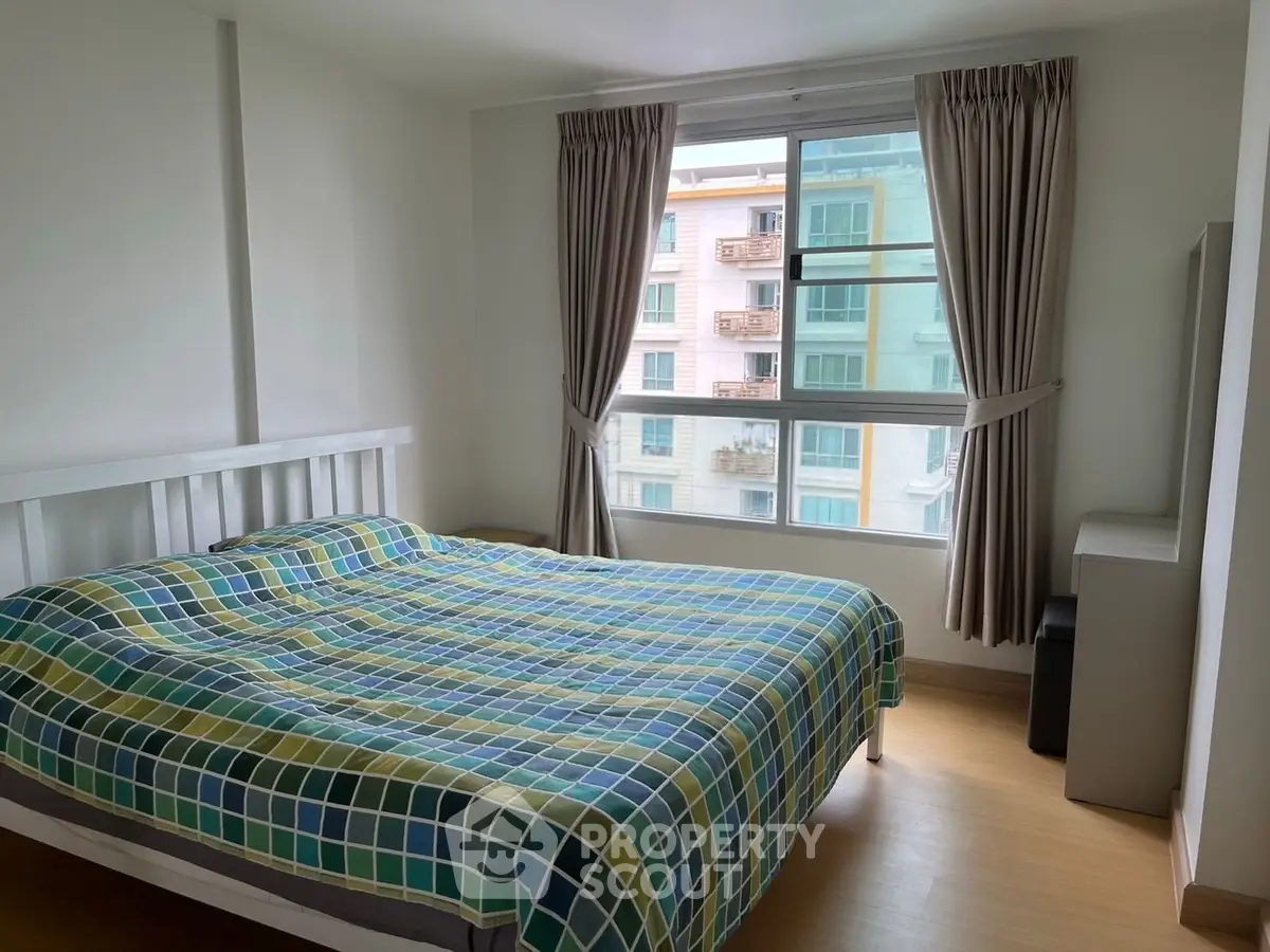 Bright bedroom with large window and modern decor in urban apartment