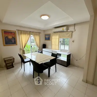 Spacious and well-lit dining area with modern furnishings, large windows offering natural light, and a serene outdoor view, perfect for family gatherings.