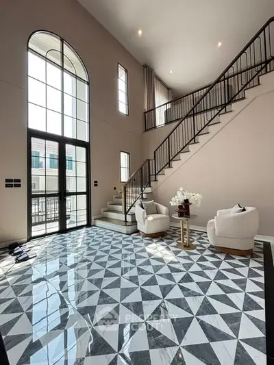 Luxurious living room with high ceilings and elegant staircase