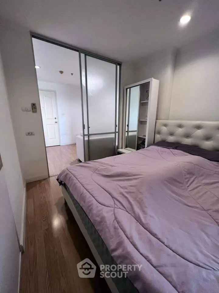 Cozy bedroom with modern decor and sliding glass door in a stylish apartment.