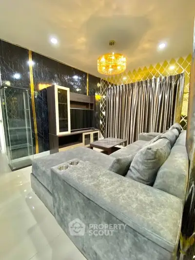Luxurious modern living room with plush grey sofa and elegant chandelier
