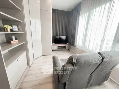Modern living room with sleek furniture and large windows offering natural light.
