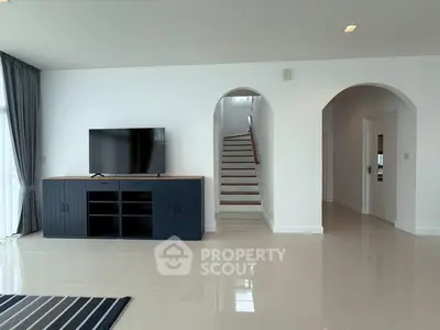 Spacious modern living room with sleek TV unit and elegant staircase