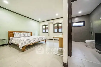 Spacious bedroom with ensuite bathroom, featuring modern design and ample natural light.