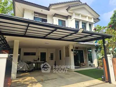 Spacious modern house with covered carport and lush greenery, perfect for family living.