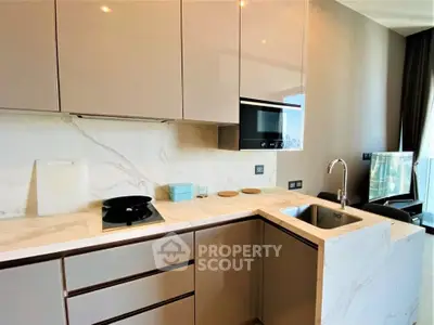 Modern kitchen with sleek cabinetry and marble countertops in a luxury apartment.