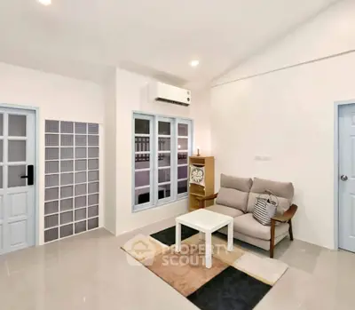 Modern living room with cozy sofa, stylish decor, and air conditioning in a bright, spacious apartment.