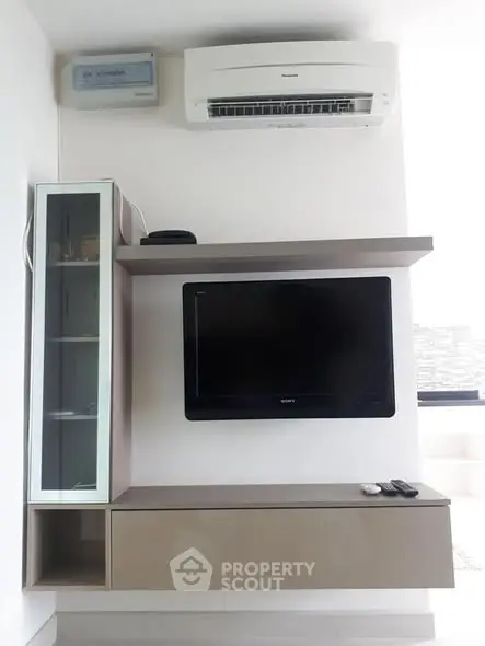 Modern living room with wall-mounted TV and air conditioning unit.