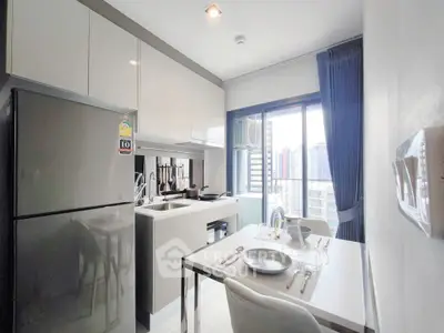 Modern kitchen with dining area and city view, sleek cabinetry and appliances.