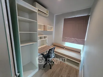 Modern study room with built-in desk, shelves, and cozy seating area.