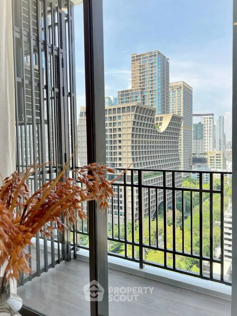 Stunning city view from modern balcony with sleek railing and vibrant greenery.