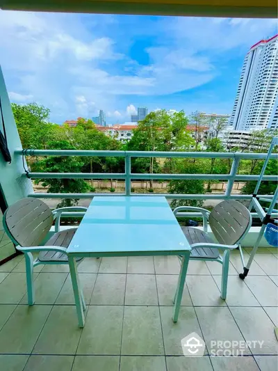 Charming balcony with modern furniture and stunning city view, perfect for relaxation.