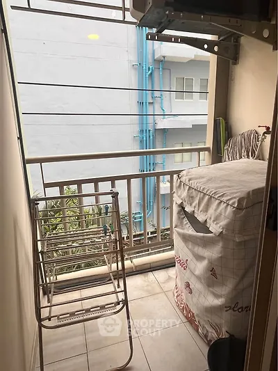 Compact balcony with laundry area and city view, ideal for urban living.