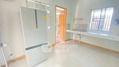 Bright kitchen with modern fridge and ample natural light