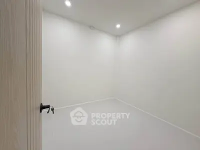Minimalist empty room with white walls and modern lighting, perfect for customization.