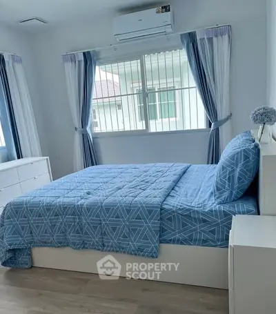 Bright and cozy bedroom with blue bedding and natural light