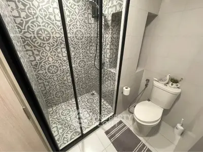 Modern bathroom with stylish patterned shower tiles and sleek fixtures
