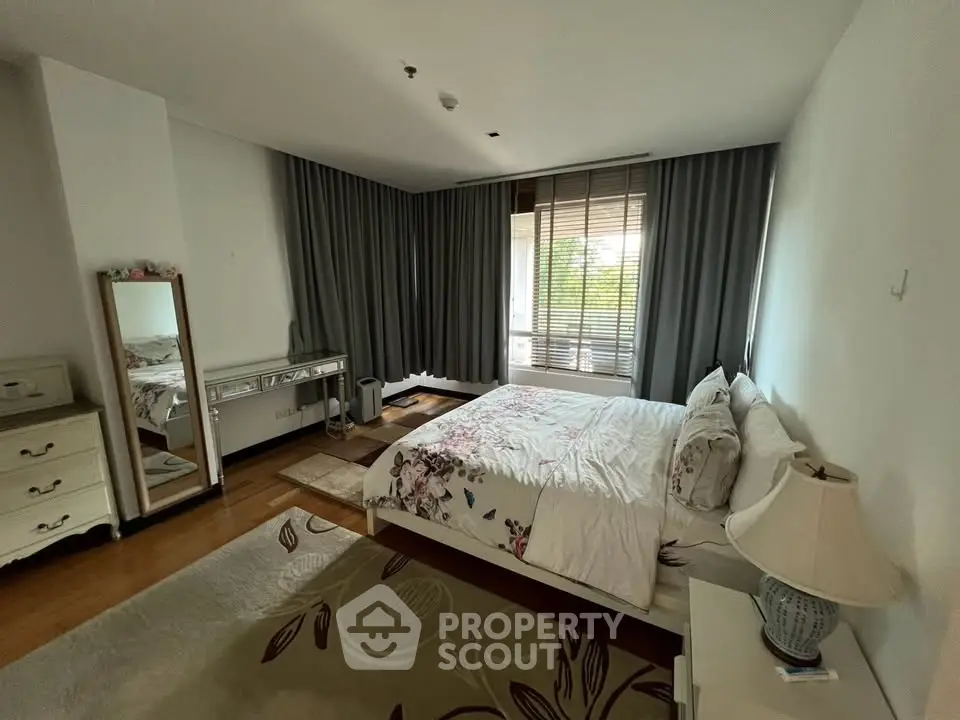 Spacious bedroom with elegant decor and large window for natural light