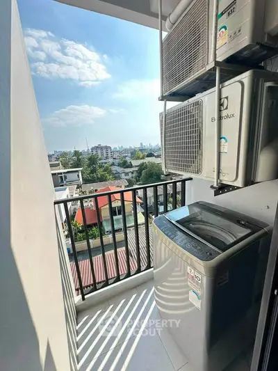Charming balcony with washing machine and city view, perfect for urban living convenience.
