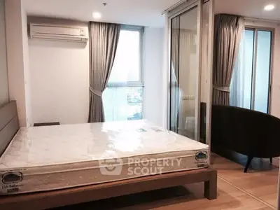 Modern bedroom with large windows and air conditioning in a stylish apartment.