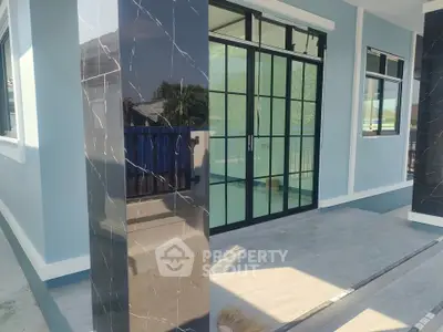 Modern exterior with sleek glass doors and marble accents