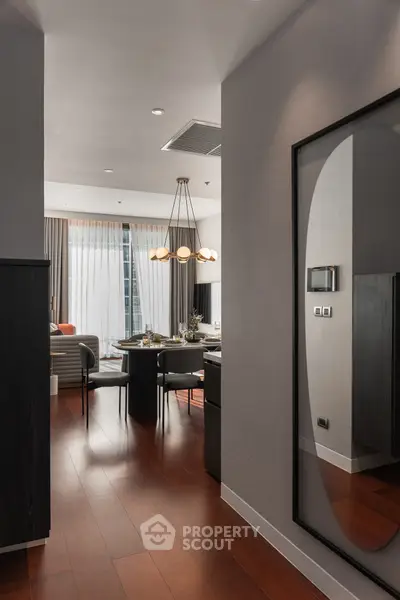 Modern living room with elegant dining area and stylish lighting fixtures.