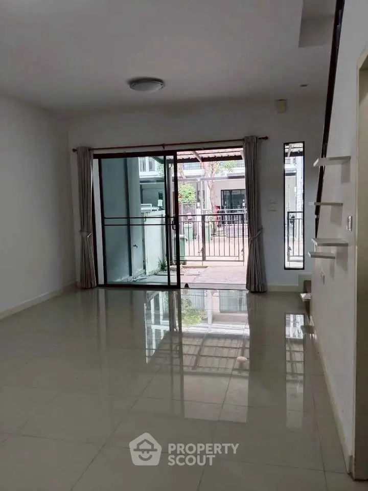 Spacious living room with sliding glass doors leading to a balcony, perfect for natural light and outdoor access.