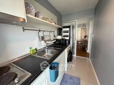 Modern kitchen with sleek countertops and stainless steel appliances in a stylish apartment.
