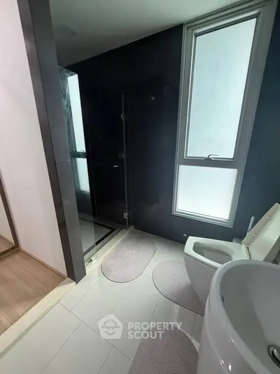 Modern bathroom with sleek black shower and large window for natural light.