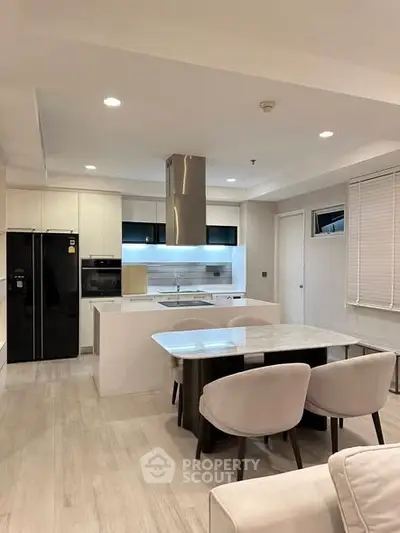 Modern kitchen with sleek design, featuring an open layout, built-in oven, and elegant dining area.