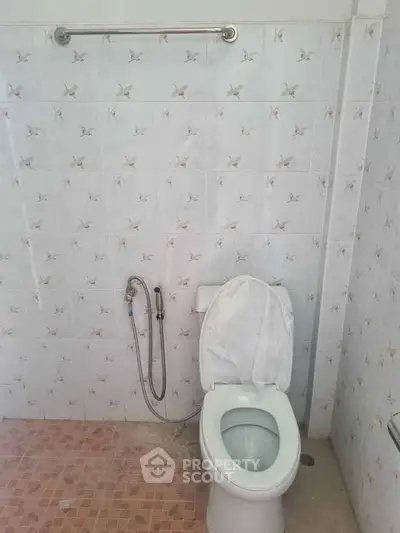 Spacious bathroom with tiled walls and modern toilet fixture.