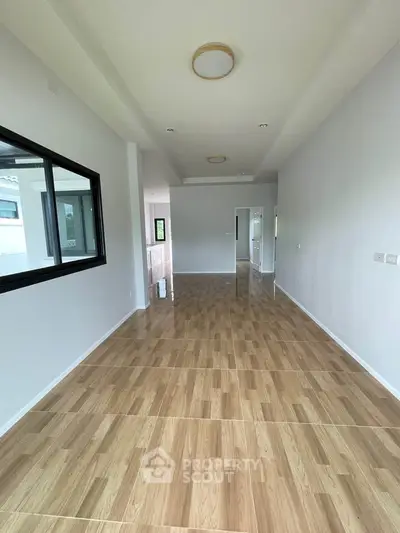 Spacious open-plan living area with wooden flooring and modern lighting
