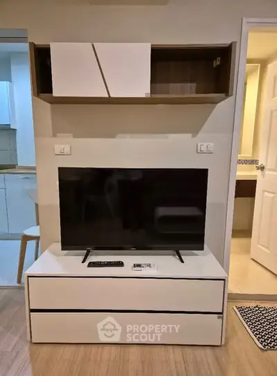 Modern living room with sleek TV stand and open kitchen view