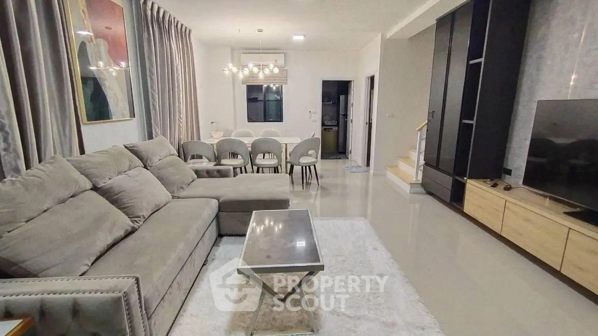 Spacious modern living room with plush sofa and elegant dining area, perfect for family gatherings.