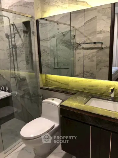 Luxurious modern bathroom with glass shower and elegant marble finishes.