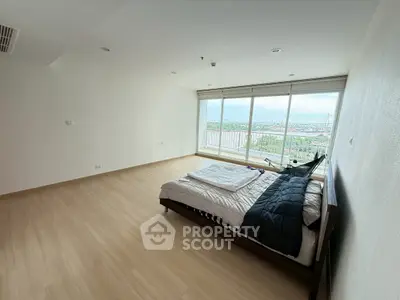 Spacious bedroom with panoramic city view and modern minimalist design.